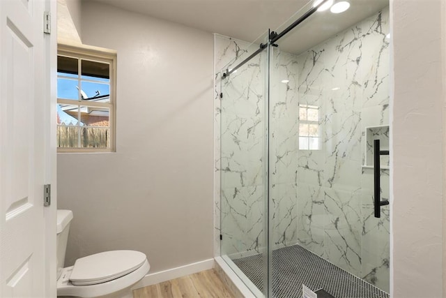 bathroom featuring wood-type flooring, toilet, and a shower with shower door