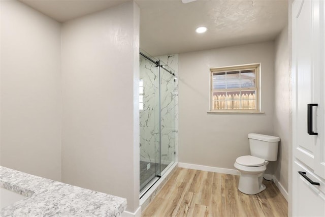 bathroom with walk in shower, toilet, and hardwood / wood-style flooring