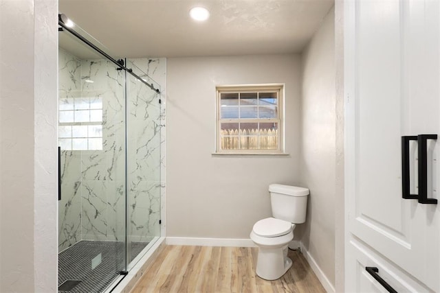 bathroom featuring wood-type flooring, an enclosed shower, and toilet