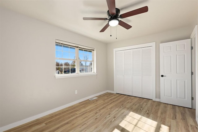 unfurnished bedroom featuring a closet, light hardwood / wood-style flooring, and ceiling fan