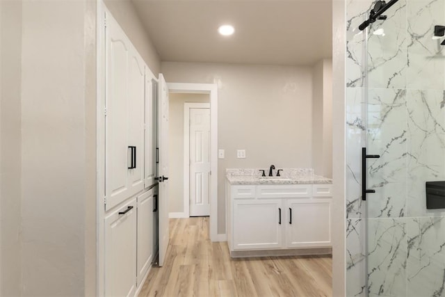 bathroom with vanity, wood-type flooring, and an enclosed shower