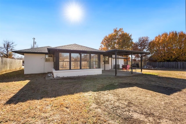 back of house featuring a yard and a sunroom