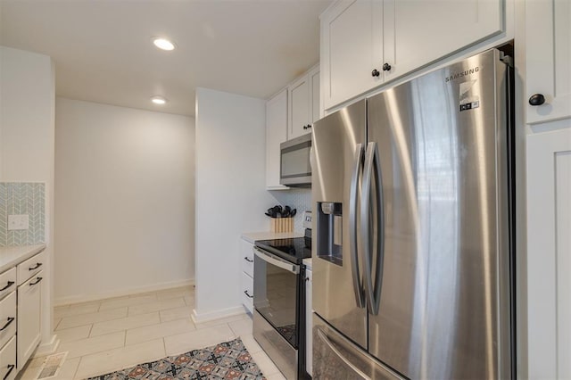 kitchen featuring white cabinets, appliances with stainless steel finishes, decorative backsplash, and light tile patterned flooring