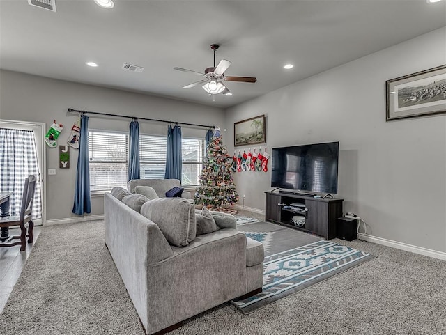 carpeted living room with ceiling fan