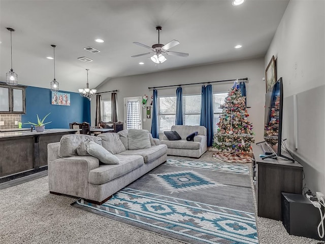 carpeted living room featuring ceiling fan with notable chandelier