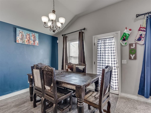 dining room featuring a chandelier, wood-type flooring, and vaulted ceiling