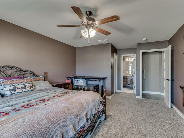 carpeted bedroom with ensuite bathroom and ceiling fan