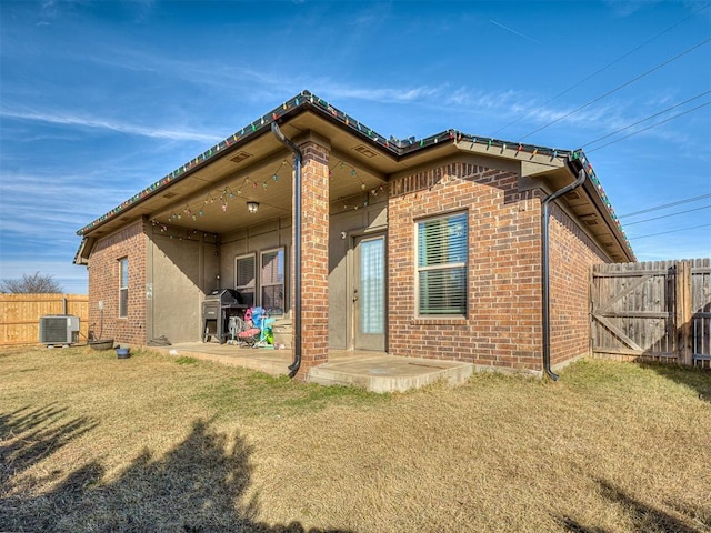 back of house featuring a patio, central AC, and a lawn