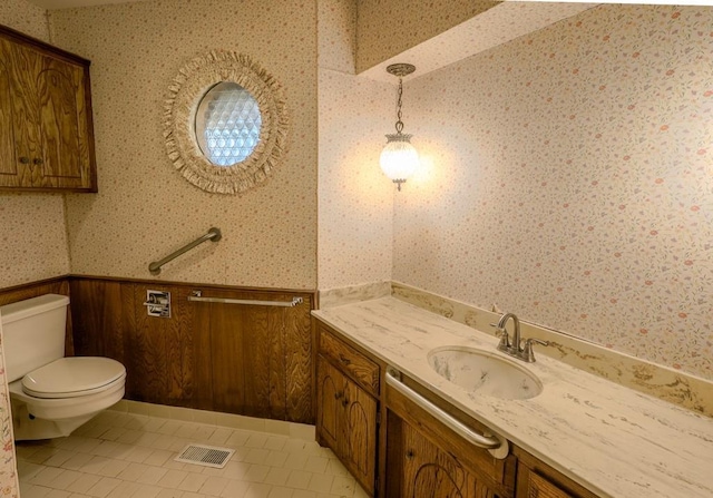 bathroom with tile patterned flooring, vanity, and toilet