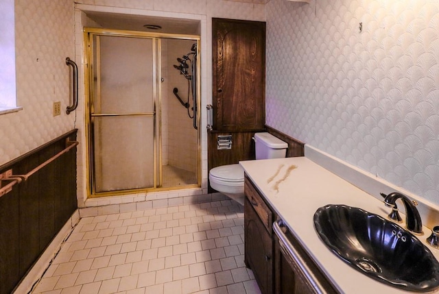 bathroom with toilet, tile patterned flooring, vanity, and walk in shower