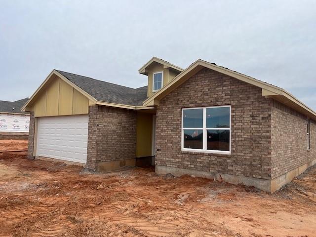 view of front facade with a garage and brick siding