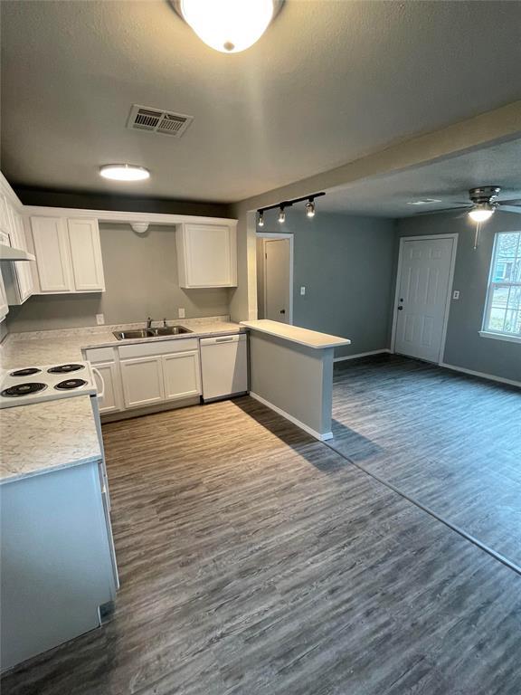 kitchen with white dishwasher, dark hardwood / wood-style flooring, white cabinetry, and sink