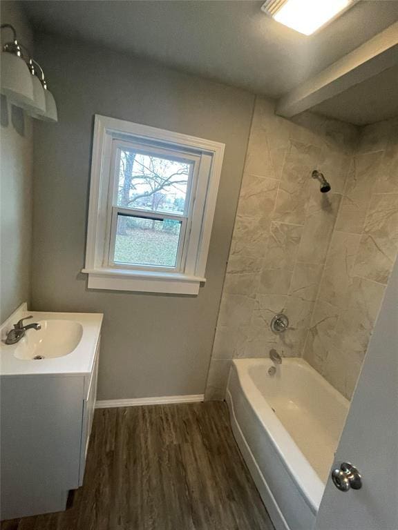 bathroom featuring hardwood / wood-style flooring, vanity, and tiled shower / bath