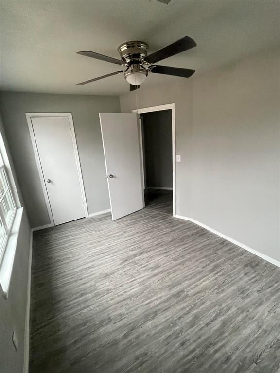 unfurnished bedroom with ceiling fan and dark hardwood / wood-style flooring