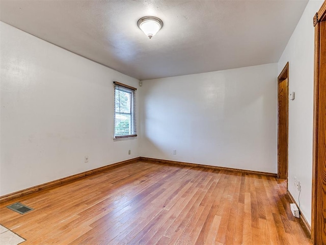 unfurnished room with light hardwood / wood-style floors