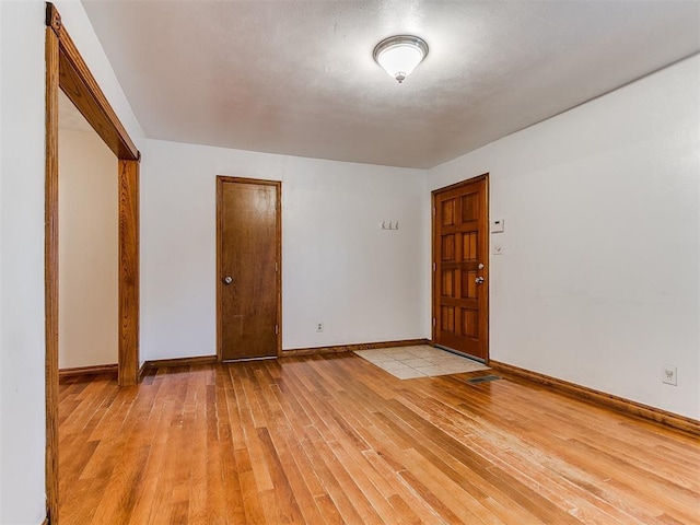 empty room with light hardwood / wood-style flooring