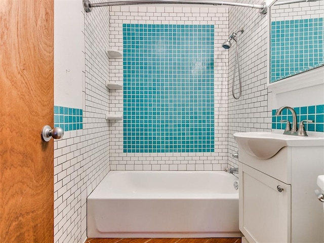 bathroom featuring vanity, tile walls, and tiled shower / bath