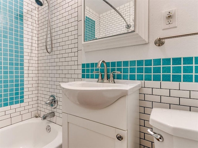 full bathroom with tiled shower / bath combo, toilet, tile walls, and vanity