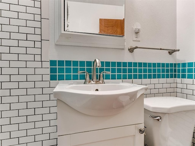 bathroom featuring vanity, toilet, and tile walls