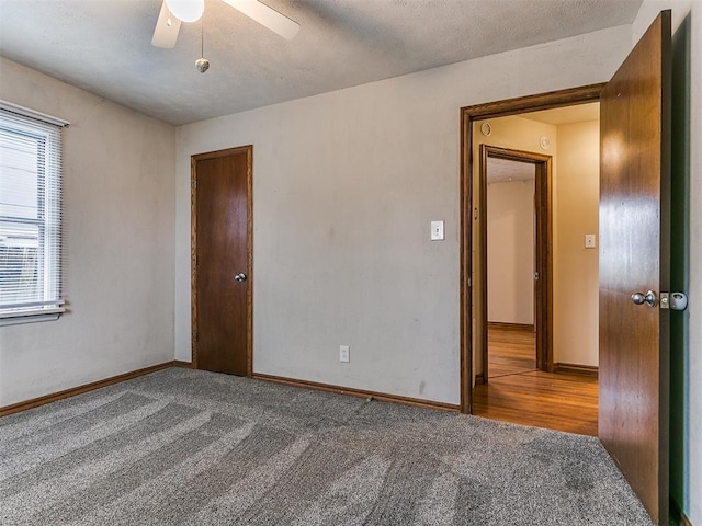 empty room with a textured ceiling, carpet floors, and ceiling fan