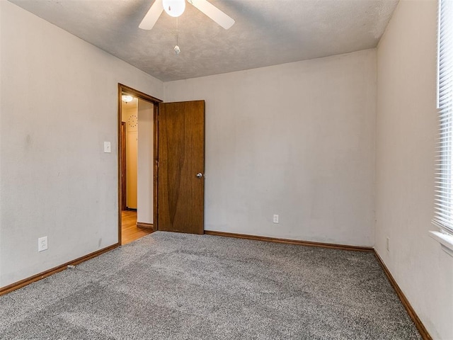 carpeted empty room with a textured ceiling and ceiling fan