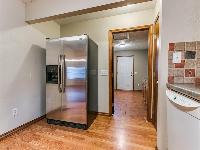 kitchen featuring dishwasher, light hardwood / wood-style floors, stainless steel fridge with ice dispenser, and backsplash