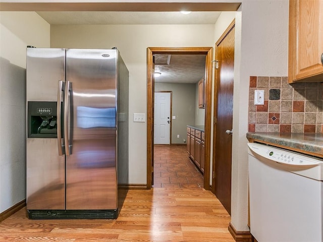 kitchen with backsplash, white dishwasher, stainless steel refrigerator with ice dispenser, light wood-type flooring, and light brown cabinetry