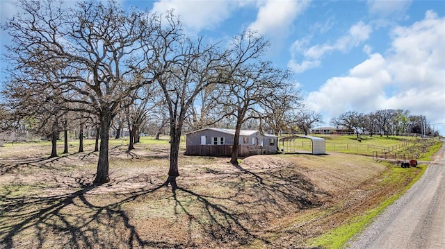 view of front of home with a rural view and a carport