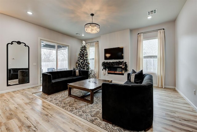 living room with light hardwood / wood-style flooring and a chandelier