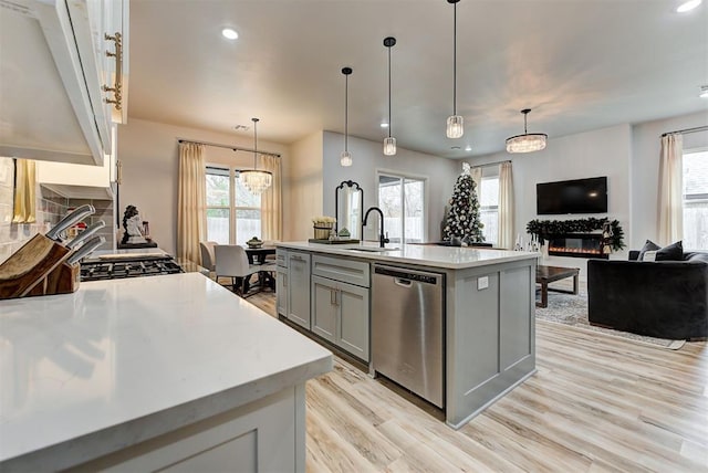 kitchen with a wealth of natural light, an island with sink, and appliances with stainless steel finishes