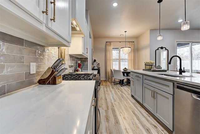 kitchen with decorative light fixtures, stainless steel appliances, plenty of natural light, and sink