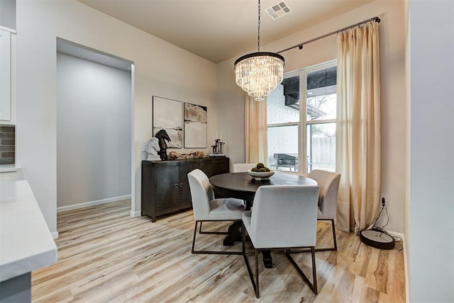 dining area featuring light wood-type flooring and a chandelier