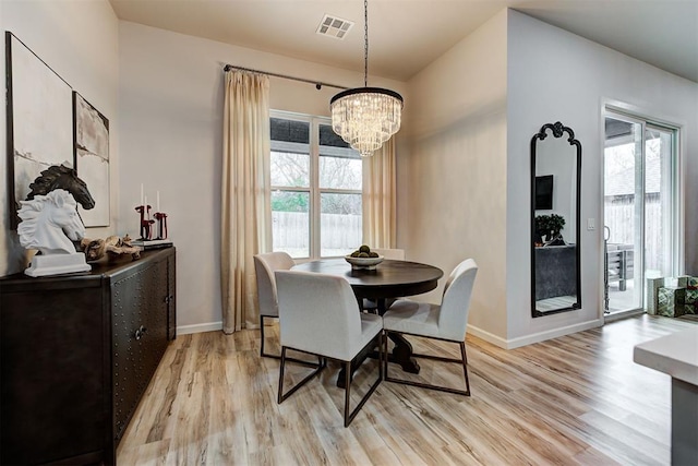 dining room featuring light hardwood / wood-style flooring and a notable chandelier