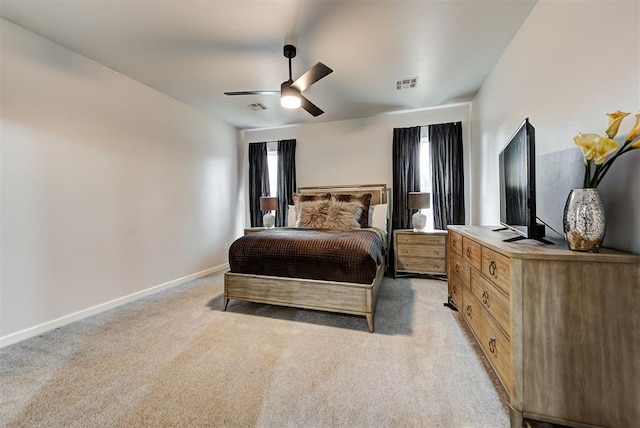 bedroom with multiple windows, ceiling fan, and light carpet