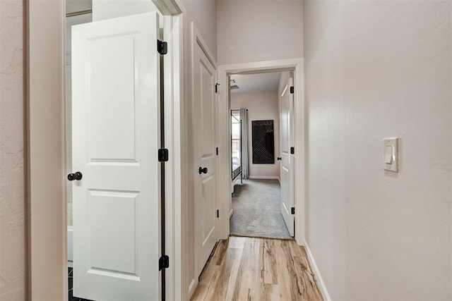 hallway with light hardwood / wood-style floors