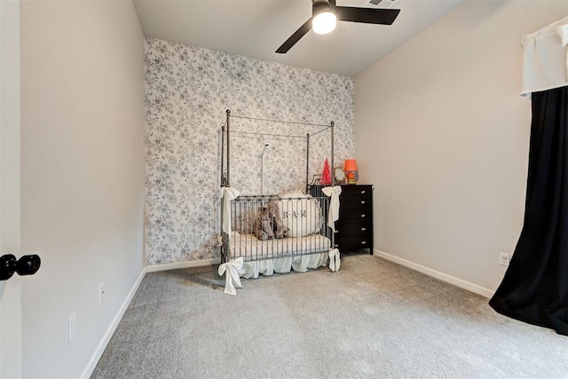 carpeted bedroom with a nursery area and ceiling fan