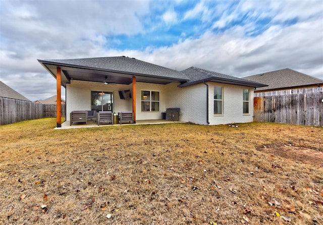 back of property featuring a patio area, an outdoor living space, a yard, and ceiling fan