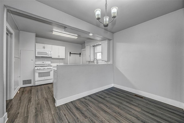 kitchen with pendant lighting, white appliances, an inviting chandelier, dark hardwood / wood-style floors, and white cabinetry