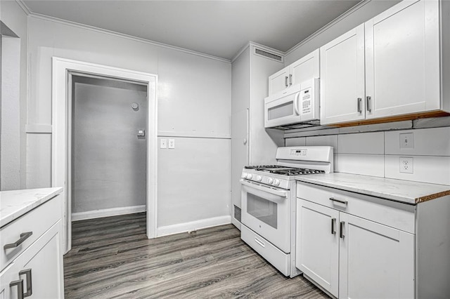 kitchen featuring white cabinetry, dark wood-type flooring, light stone counters, white appliances, and ornamental molding