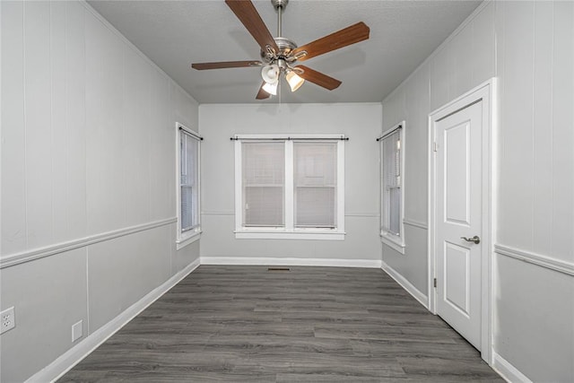 unfurnished room with a textured ceiling, dark hardwood / wood-style floors, and ceiling fan