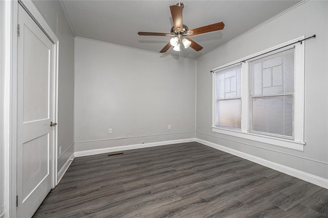 empty room with crown molding, ceiling fan, and dark hardwood / wood-style floors