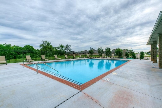 community pool featuring a patio and fence