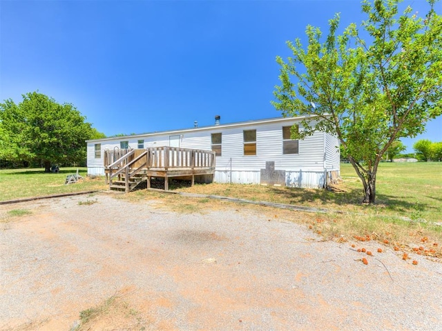 view of front of house featuring a deck and a front lawn