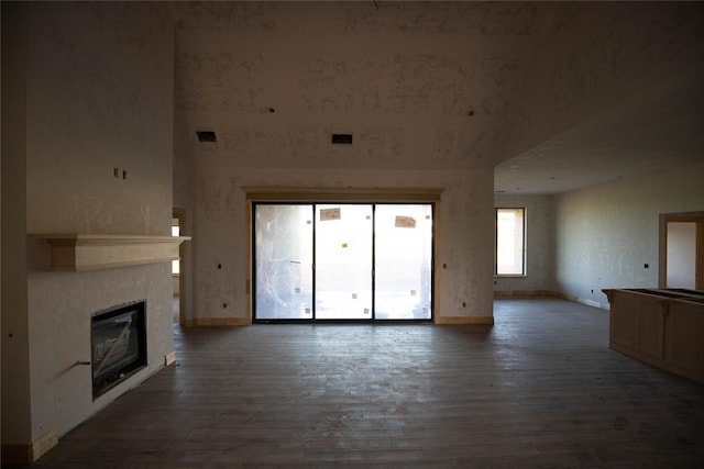 5800 Lantana Ln, Edmond, OK 73034 - unfurnished living room featuring baseboards, hardwood / wood-style floors, and a glass covered fireplace