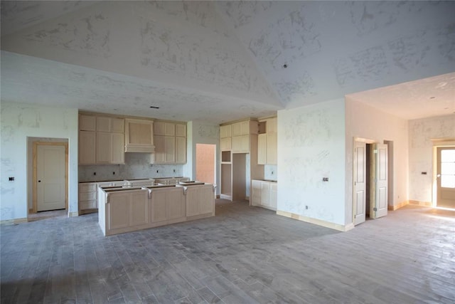 5800 Lantana Ln, Edmond, OK 73034 - kitchen with lofted ceiling, wood finished floors, open floor plan, an island with sink, and baseboards