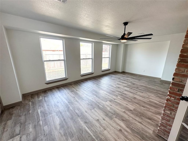 spare room featuring wood-type flooring, a textured ceiling, and ceiling fan