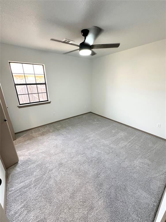 empty room featuring ceiling fan and light carpet