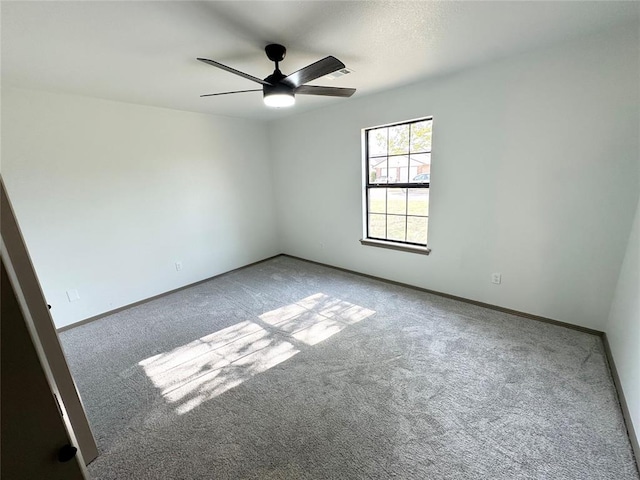 carpeted spare room featuring ceiling fan