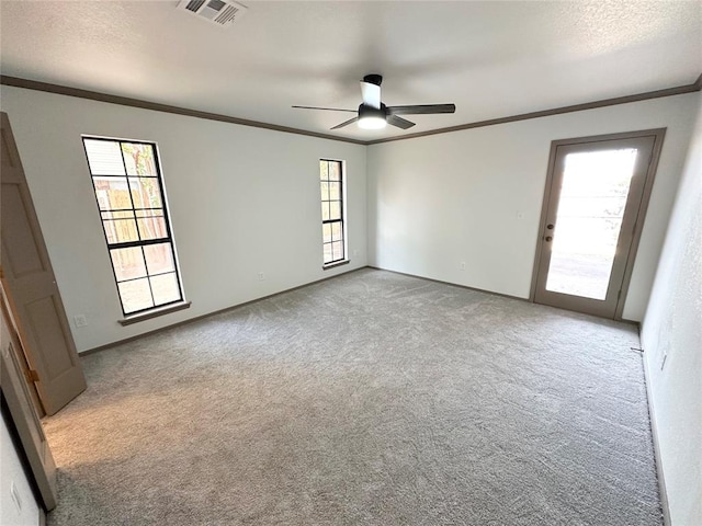 carpeted spare room featuring ceiling fan and crown molding