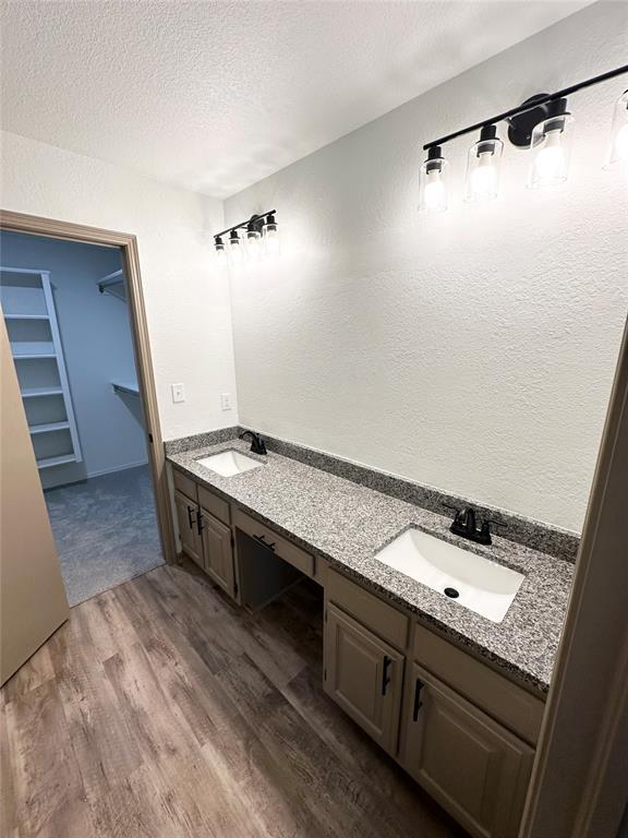 bathroom featuring hardwood / wood-style floors, vanity, and a textured ceiling